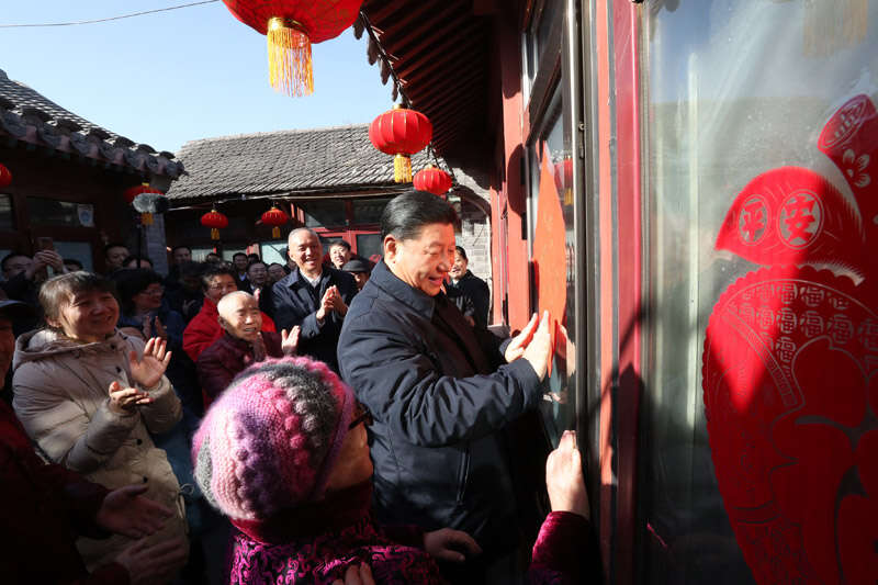 2019年2月1日上午，習(xí)近平在北京前門東區(qū)草廠四條胡同32號(hào)院，高興地拿起一幅“?！弊郑H自貼到門上，給這里的老街坊們拜年。新華社記者 鞠鵬 攝