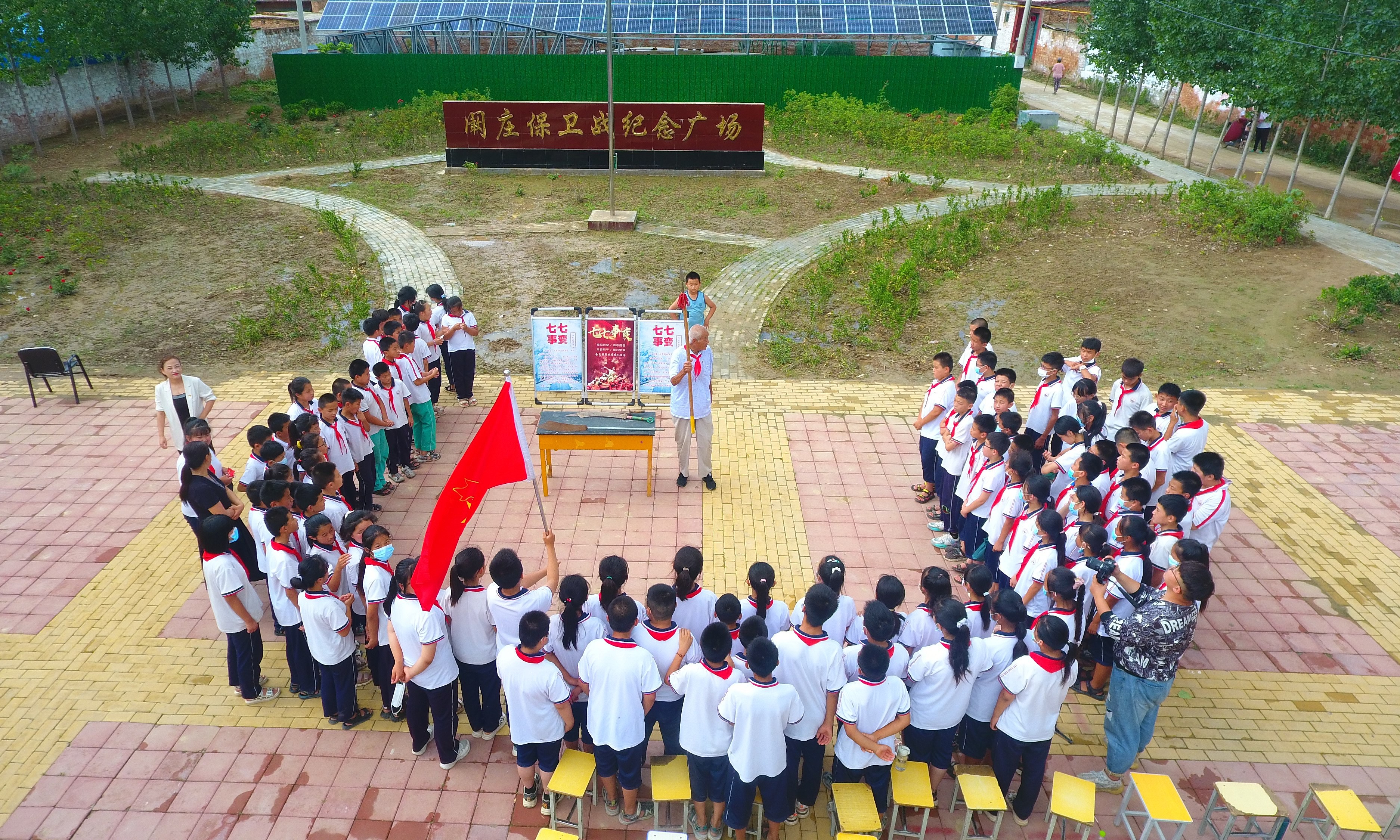 2022年7月6日，山東省聊城市，在茌平區(qū)菜屯鎮(zhèn)闞莊村的闞莊保衛(wèi)戰(zhàn)紀念廣場，闞莊保衛(wèi)戰(zhàn)親歷者王光木老人，為小學(xué)生們講述抗戰(zhàn)故事，展示大刀、長矛。
