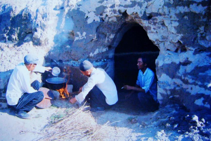 1983年，“六老漢”一代治沙人在“地窩子”生活做飯。新華社發(fā)（八步沙林場(chǎng)供圖）